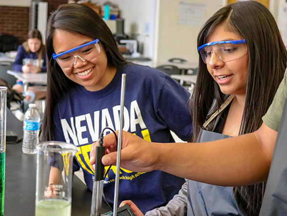 Student teaching high school kids how to do science experiment