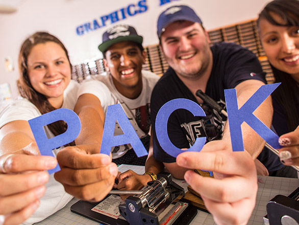 Students holding lettering the spells pack