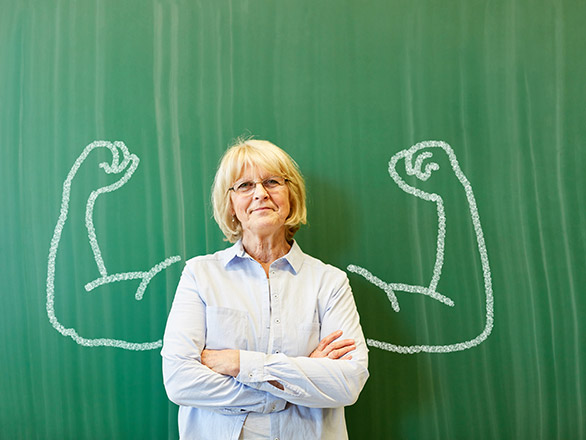 Teacher in front of chalk board with strong arms drawn around her