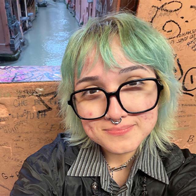 Reggio Emilia participant poses in front of Italian architecture.