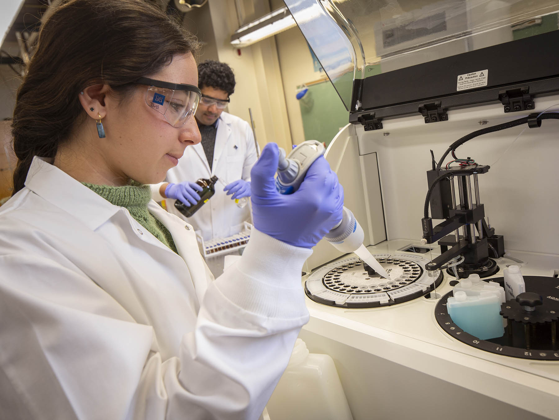 A petri dish with green leaflets floating in water