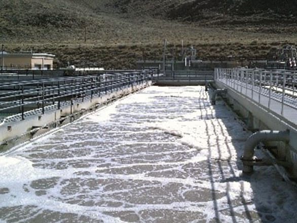 Cement channel with water flowing into it from large pipes on the right