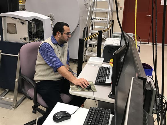 Man sitting, facing right, at computer station