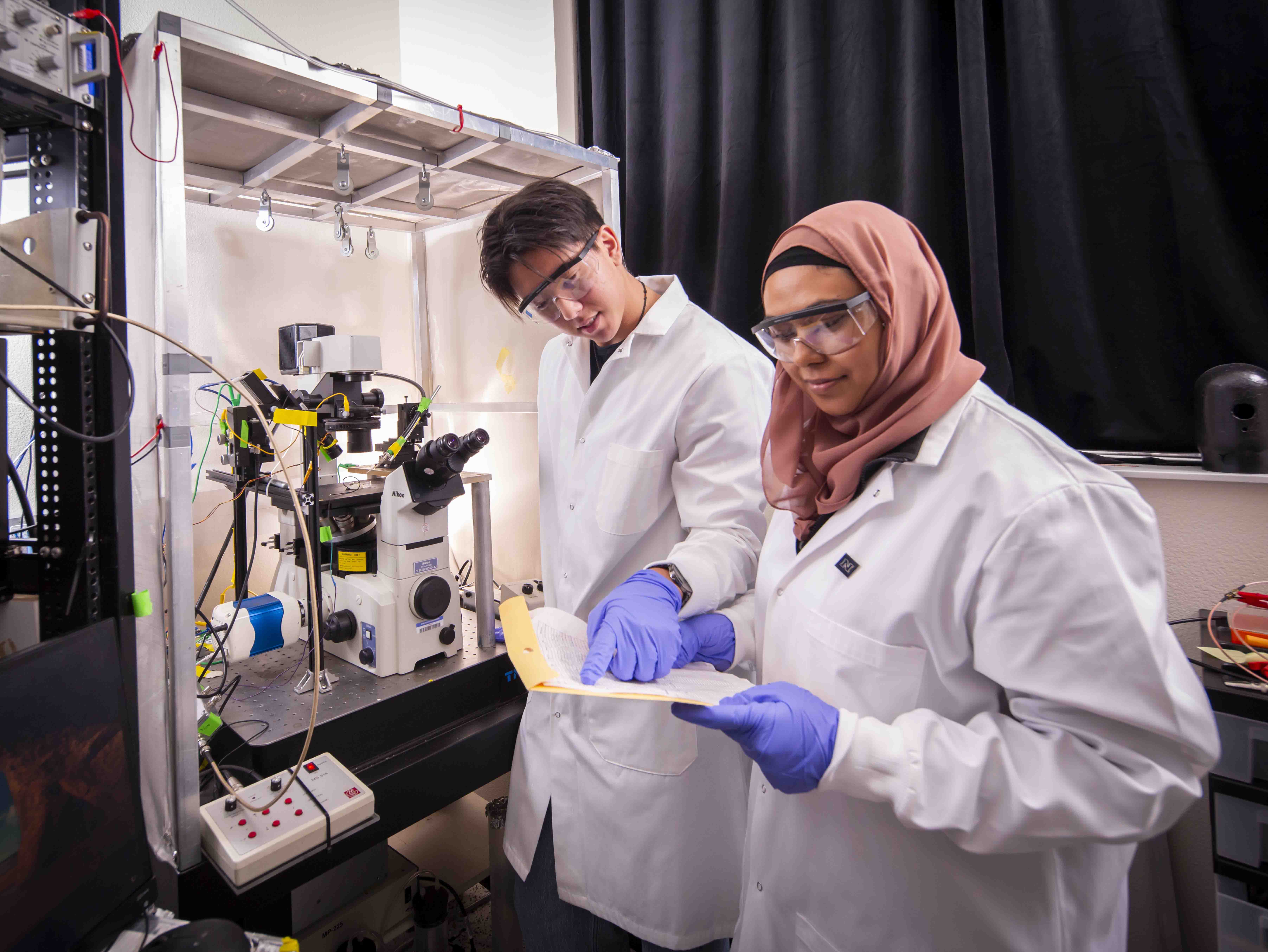Student in lab coat working on lab project