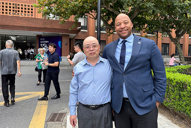 Business Professor Chunlin Liu and Erick Jones standing on a street.