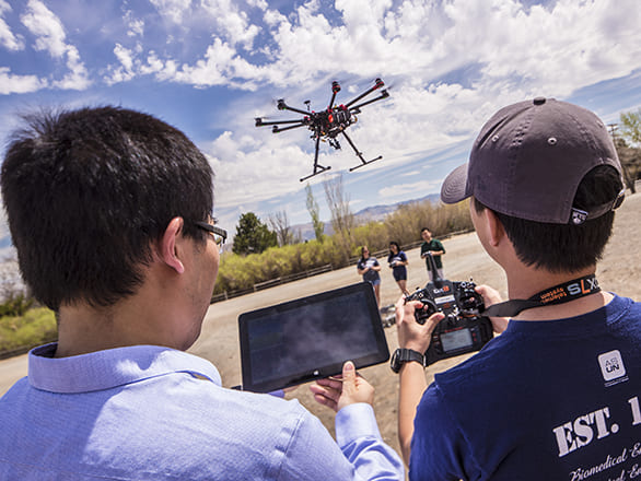student and professor flying a drone