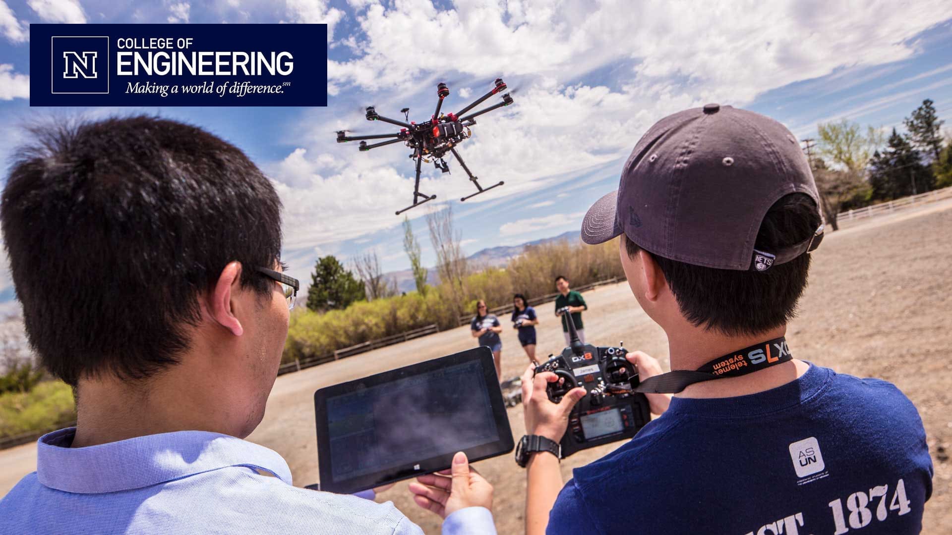 Students flying a drone with College of Engineering logo
