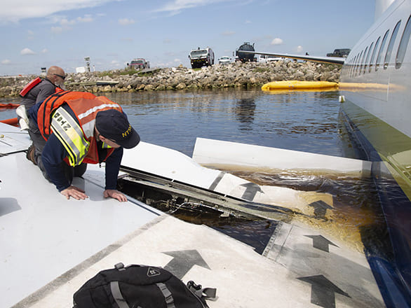Man on wing of plane in a body of water