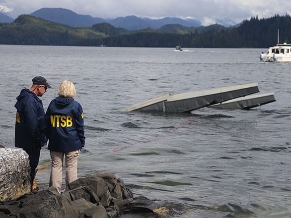 Two people looking at an airplane in a body of water