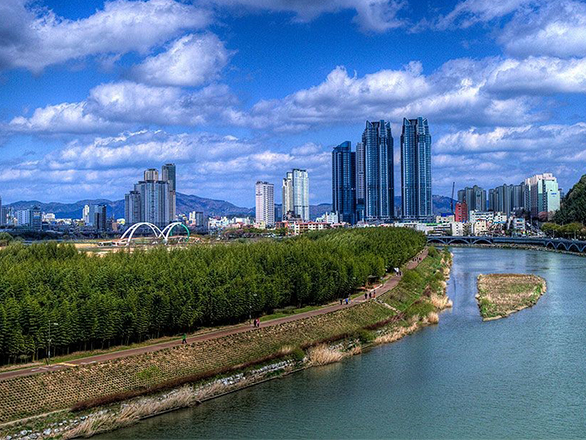 View of a bend in a river with skyscrapers in the background
