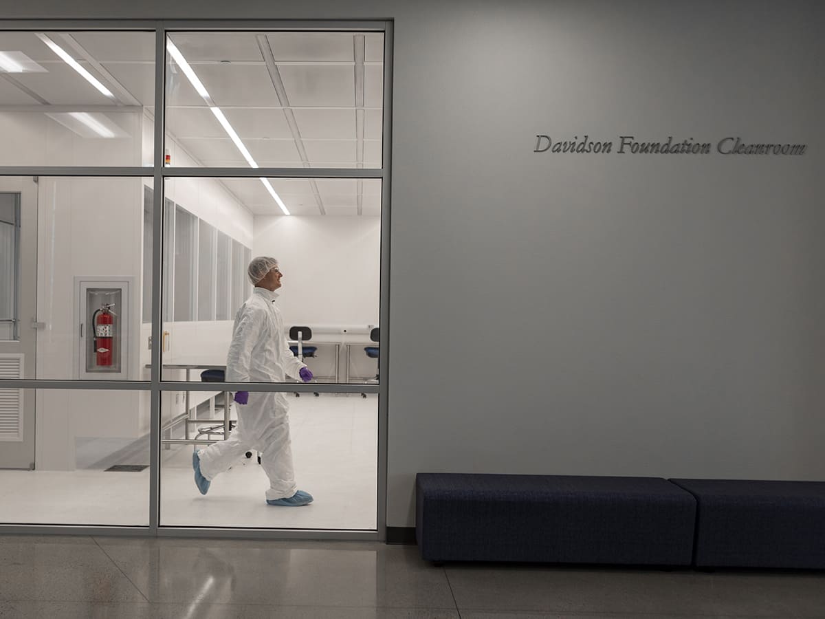person in full lab suit inside cleanroom
