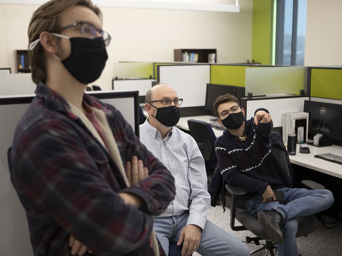 Three people talking in computer lab