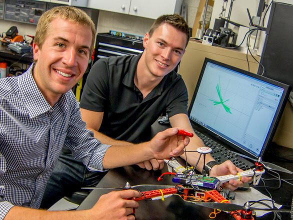 Two students at a computer working on wiring a drone