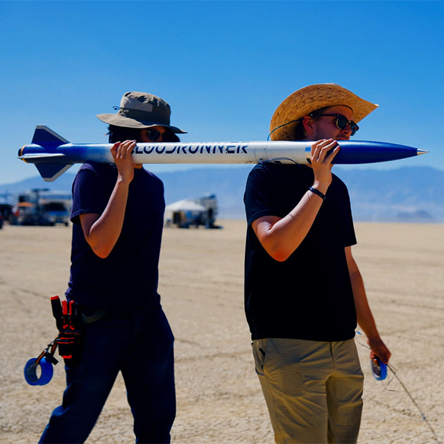 College of Engineering students carry a rocket to launch in the desert