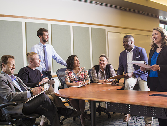 Seven people sitting around a conference table