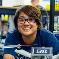 Graduate student smiling while working over equipment