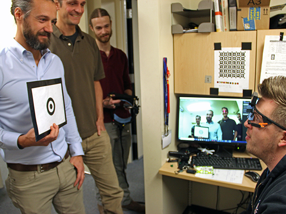 Researchers calibrating a video-recording headset.