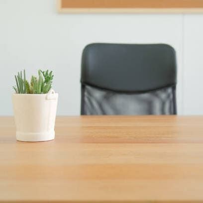 Empty desk with chair and plant