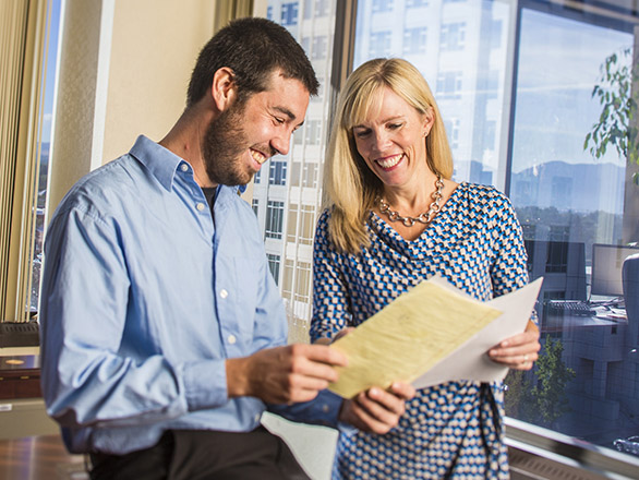 Two people in an office reviewing paperwork together.