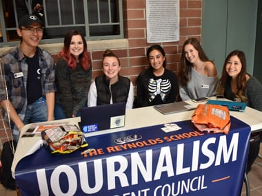 Students sit behind a table in the Reynolds School.