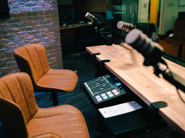 Chairs at a desk with audio recording equipment. 