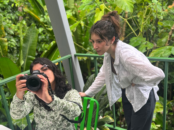 Two students in Costa Rica, one of which is holding a camera.