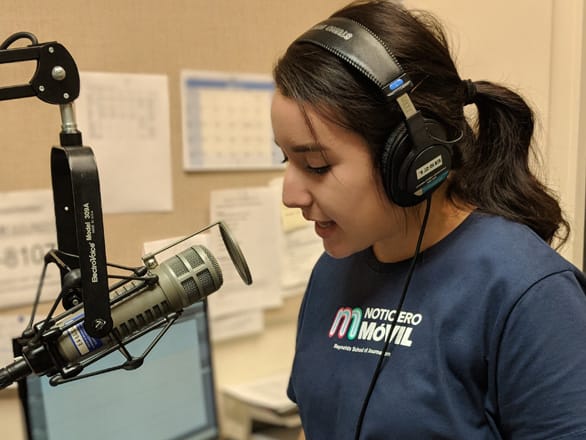 Student speaks into an audio mic in the KUNR studio.