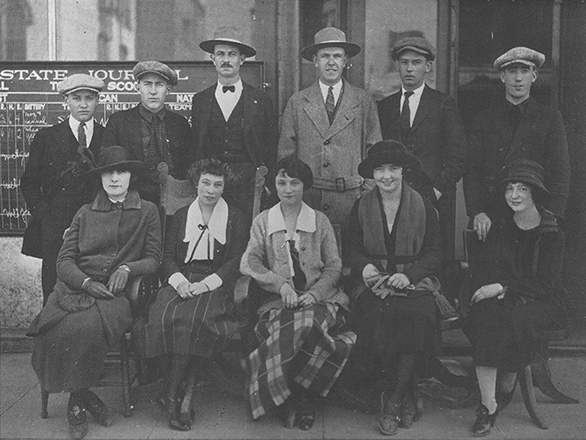 11 people sit for a portrait as the first journalism class.