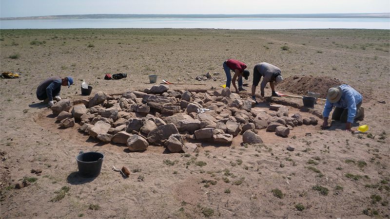 Anthropologist digging around an ancient building foundation