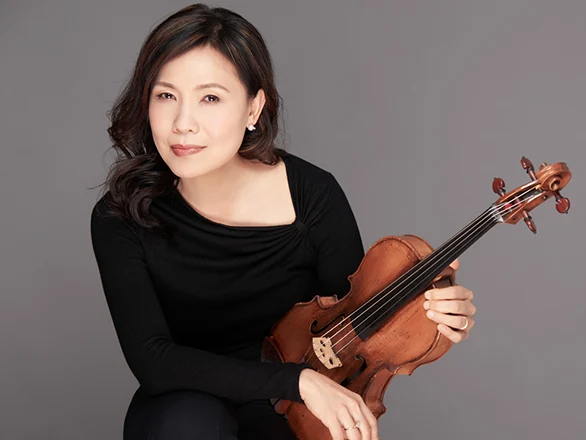 Hsin-Yun Huang wears a black sweater and poses for a photo while holding a viola.