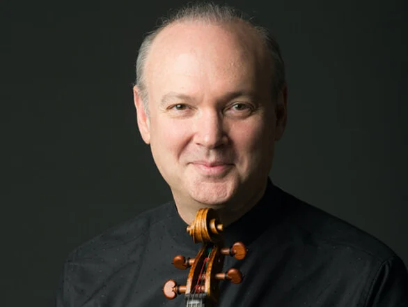 Paul Neubauer wears a black shirt and holds a viola.