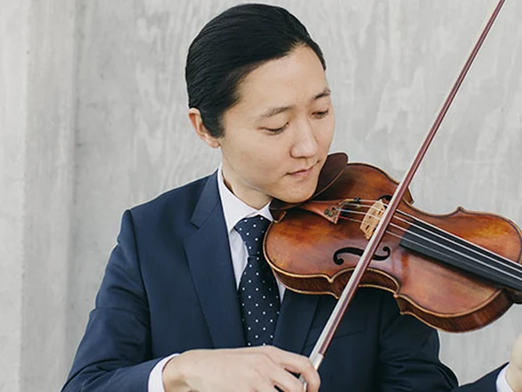 Sean Lee wears a suit and plays the violin.