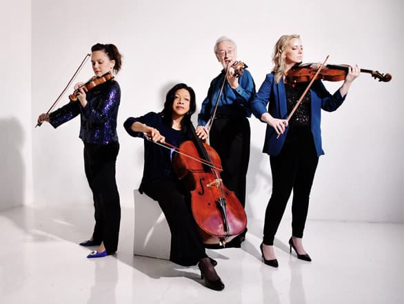 The four members of the Juilliard String Quartet pose with their instruments in a publicity photo.