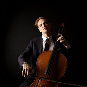 Coleman Itzkoff sits and plays the cello.