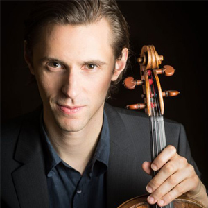 Dmitri Murrath poses for a headshot while holding a viola.