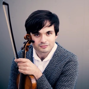 Francisco Fullana poses for a headshot while holding a violin.