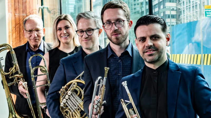 five musicians holding brass instruments