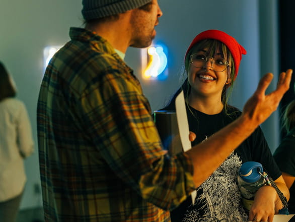 man and woman talking in art gallery