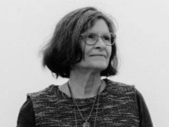 black and white headshot of Kim Abales wearing glasses