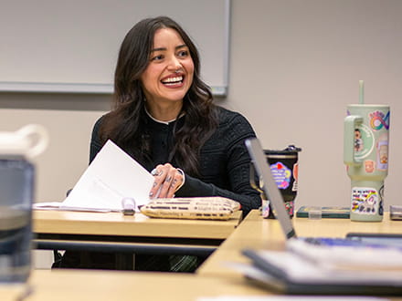 woman flipping through papers smiling