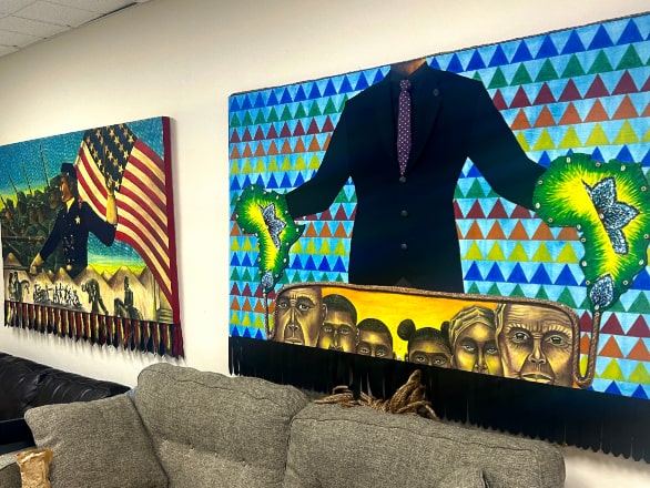 artwork on walls of soldiers with American flag and man in suit with flower hands