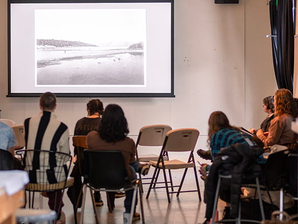 students in classroom looking at artwork on projector screen