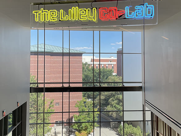 A yellow, blue and red sign inside the arts building that reads The Lilley Co-Lab