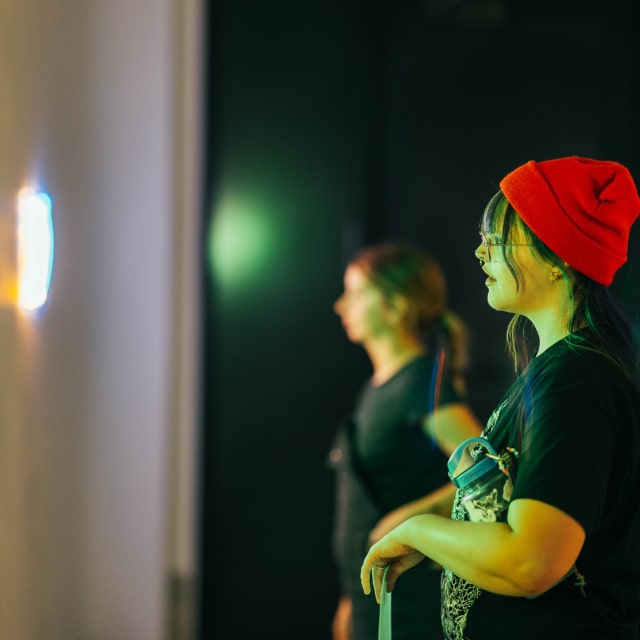 women looking at lights on wall