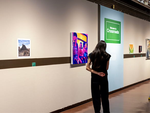 girl standing looking at artwork on wall