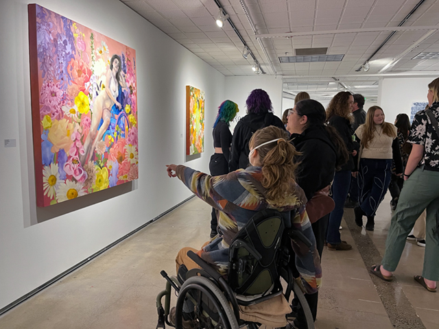 students pointing at painting on wall