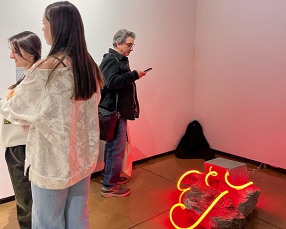 people looking at art exhibit on floor