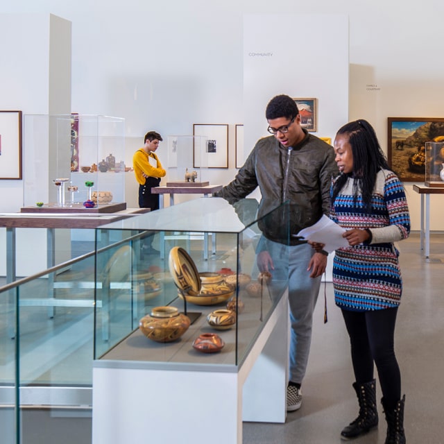 two people looking at glass museum case