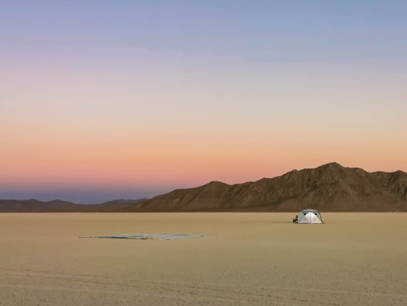 camping tent in desert at sunset