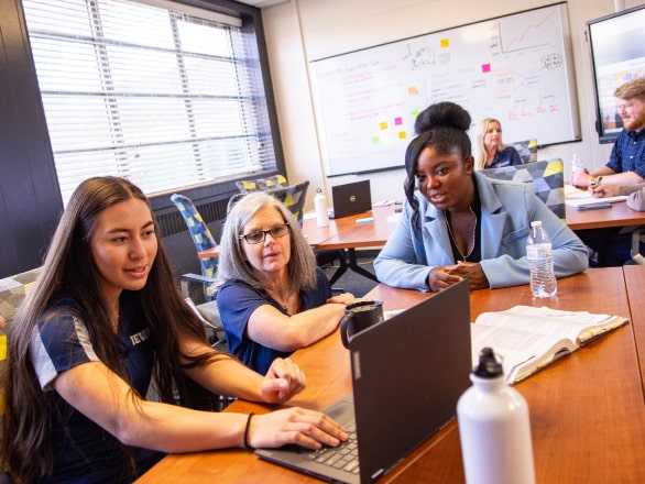 three women looking at laptop